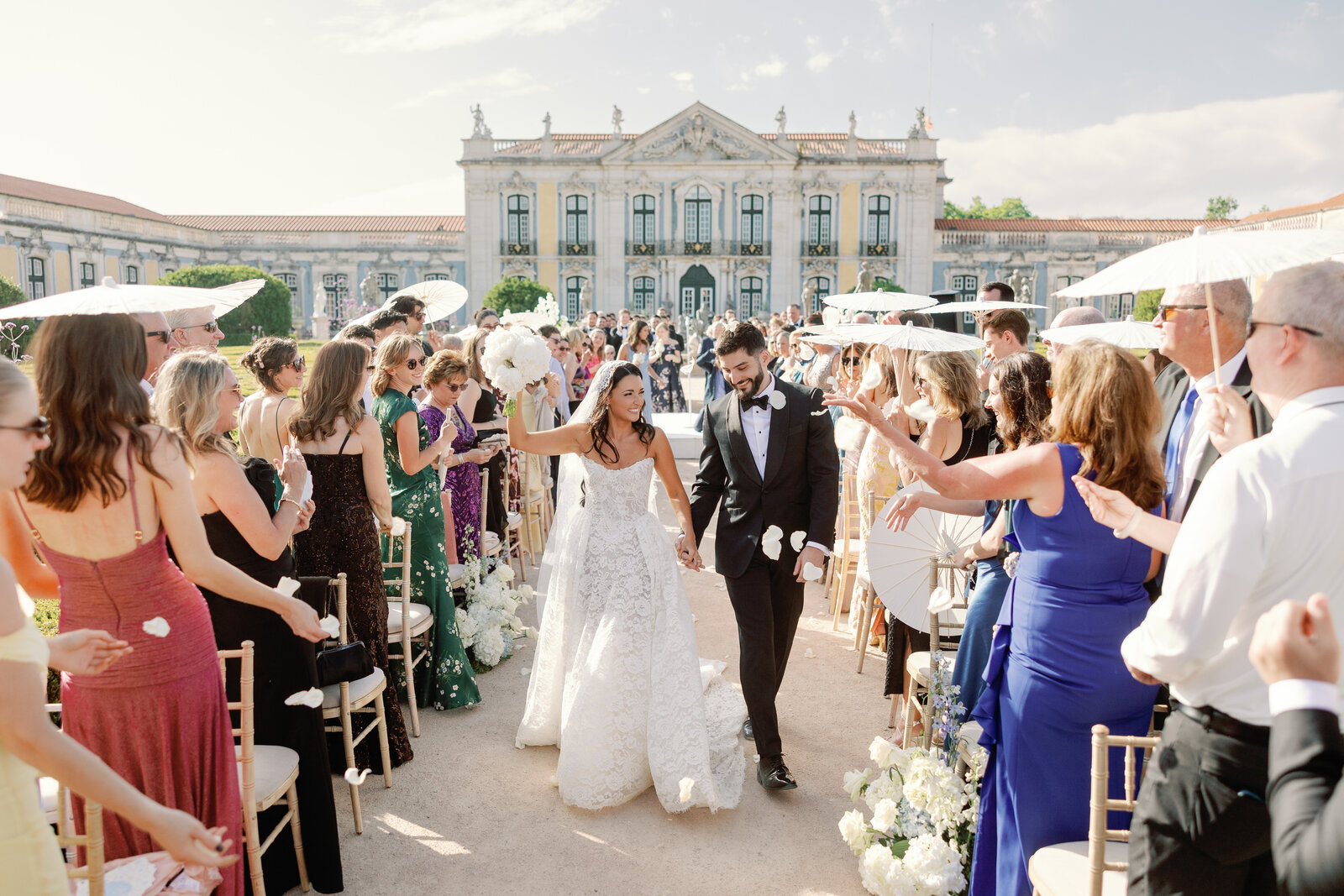 Bride and groom exiting the aisle as guests throw petals