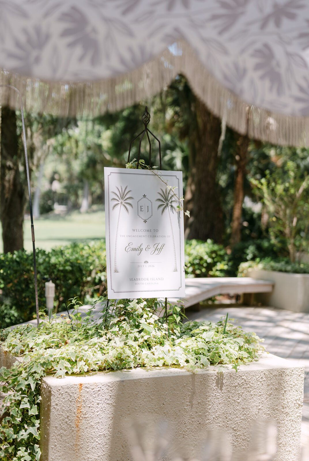 Welcome sign for Emily and Jeff's engagement celebration under a garden arbor
