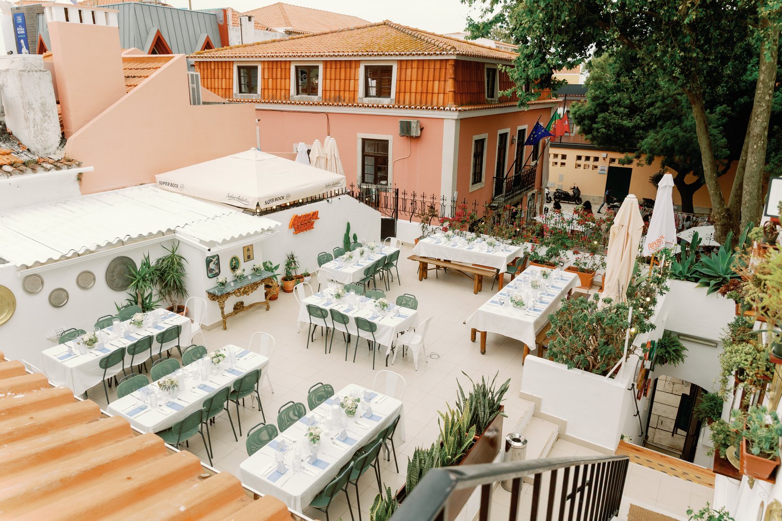 Aerial view of the rehearsal dinner rooftop terrace set for dinner